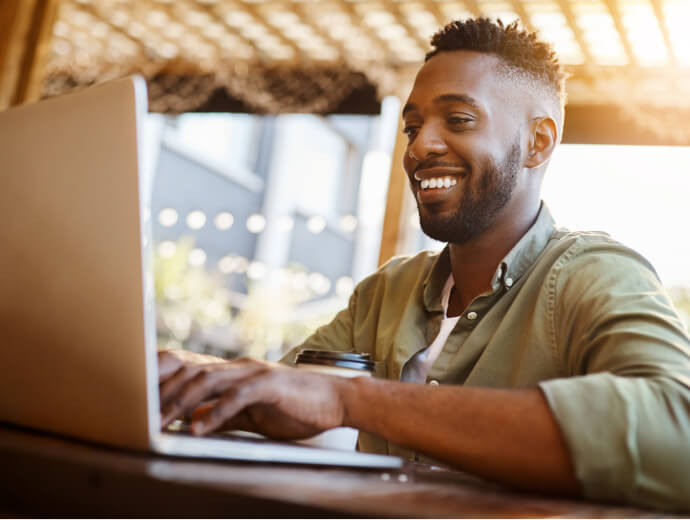 Young adult on his computer while sitting outdoors. 